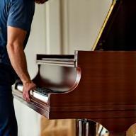 Déménageur manipulant un piano à queue avec soin